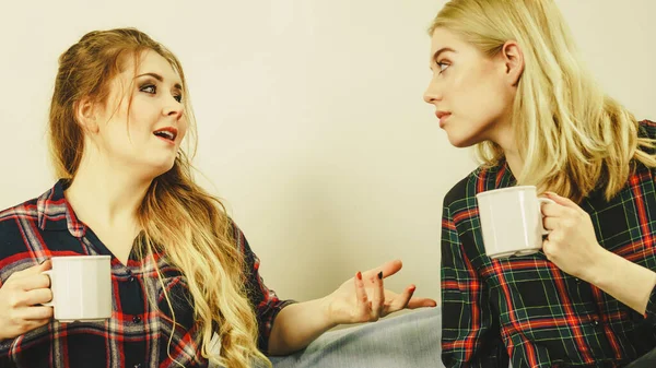 Two Female Friends Sitting Together Sofa Chatting Talking Drinking Tea — Stock Photo, Image