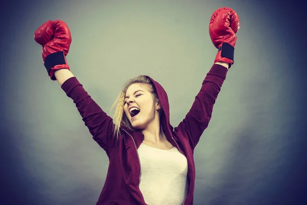 赤のボクシンググローブを身に着けているスポーティ女性は 戦いに勝つ 安心感と幸福感動機付けされています 暗い背景で撮影したスタジオ — ストック写真