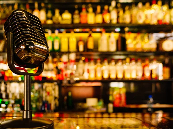 Bar Räknare Med Mikrofon Och Suddig Bakgrund Med Olika Alkoholflaskor — Stockfoto