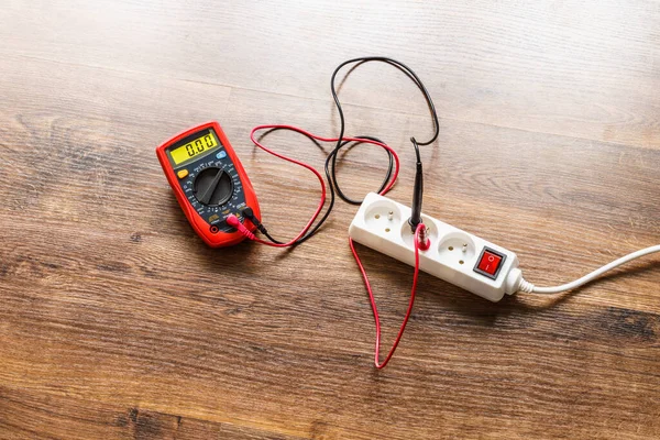 Meting Van Spanning Stopcontact Verlengsnoer Met Multimeter Houten Vloer Achtergrond — Stockfoto