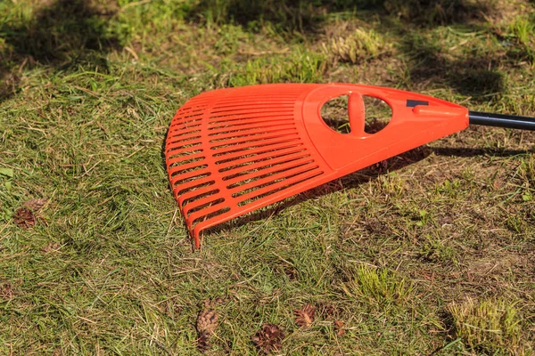 Plastik Kırmızı Tırmık Yerde Arka Planda Yeşil Çimen Tarım Bahçe — Stok fotoğraf