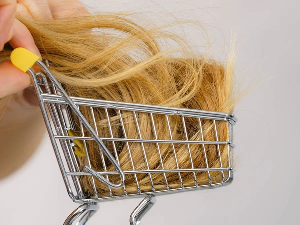 在购物车里留着一头长长的金发的女孩 理发和购物概念 — 图库照片