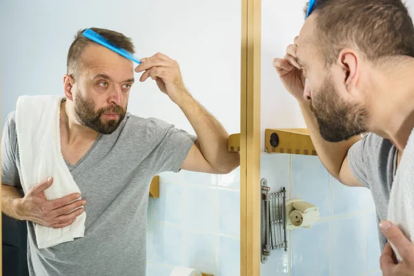 Volwassen Man Die Voor Badkamerspiegel Staat Zijn Korte Haar Borstelt — Stockfoto