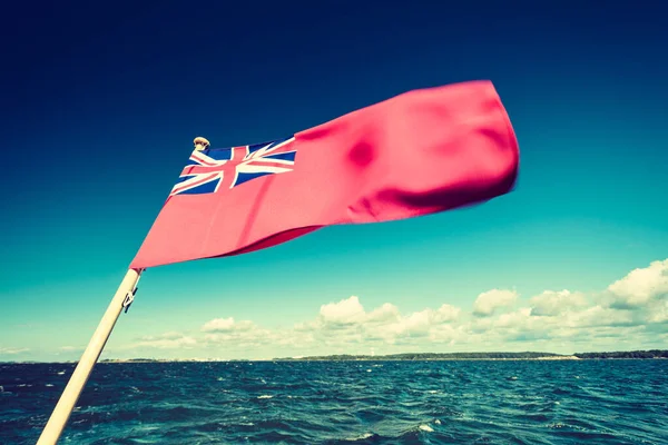 红色的英国国旗悬挂在游艇上 蓝天飘扬 海上风平浪静 夏天和旅行 — 图库照片