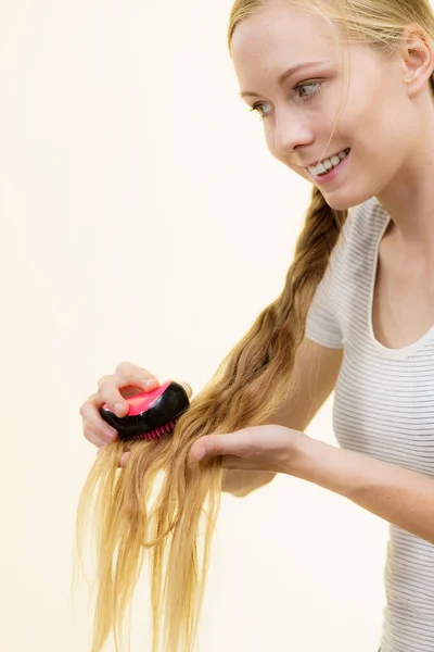 長い毛とブラシを持つブロンドの女の子 女の子は彼女の髪型をリフレッシュ世話をする ヘアケアのコンセプト — ストック写真