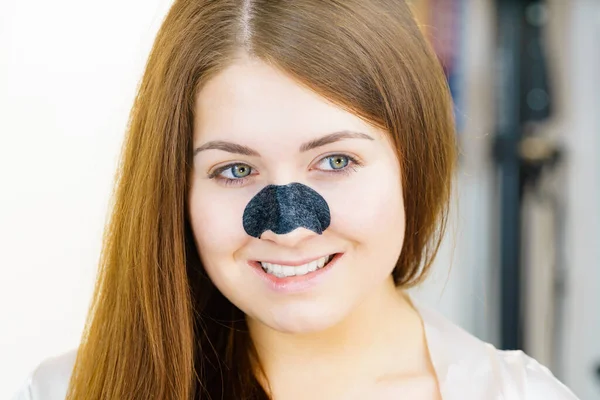 鼻に炭ストリップを持つ若い女性は 黒頭の洗浄のためのマスクを削除します 肌の色を気にする女の子 美の治療だ スキンケア — ストック写真