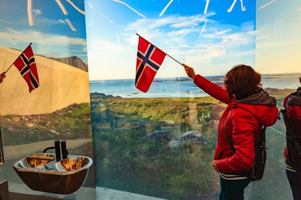 鏡のようなトイレの中から海の景色を楽しむノルウェーの国旗を持つ観光客の女性ノルウェーのヴェスターレン諸島のAndoya島のBukkekjerka休憩所 — ストック写真