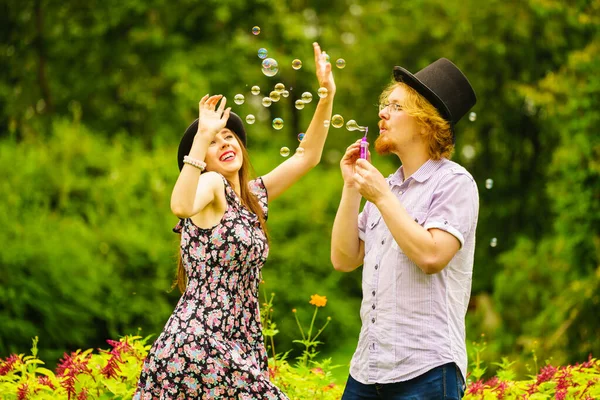 Feliz Divertido Hipster Pareja Jugando Juntos Soplando Jabón Burbujas Aire — Foto de Stock