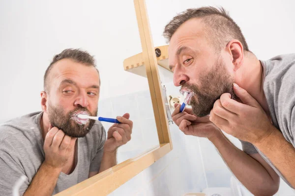 Homem Adulto Escovando Dentes Olhando Para Espelho Banheiro Durante Rotina — Fotografia de Stock