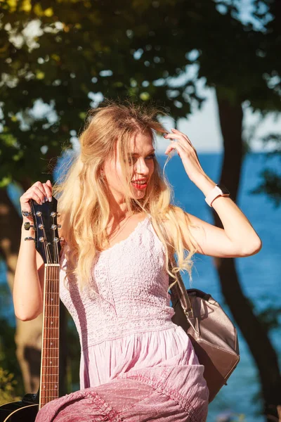 アコースティックギターを持つブロンドの女性 海辺で女性が音楽を演奏 — ストック写真