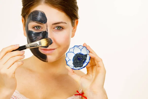 スキンケアだ 泥のカーボマスクを適用する女性 彼女の顔に深いクレンザー 女性は黒い粘土化粧品とブラシとボウルを保持しています にきび治療 — ストック写真