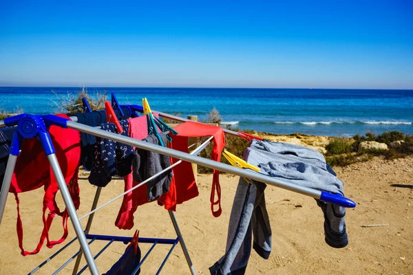ビーチでのキャンプ 冒険の概念 洗濯ラインの屋外で海に対して乾燥するためにぶら下がって服 — ストック写真