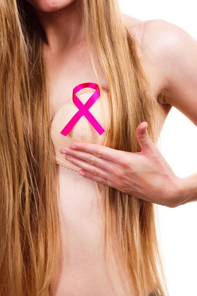 Woman wih pink ribbon on chest. Female wearing bra showing symbol representing awareness, hope and moral support for breast cancer patients.