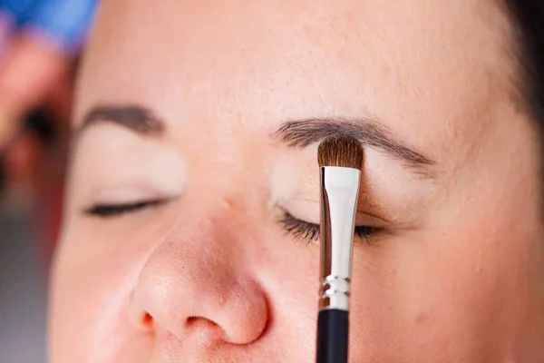 人脸彩绘化妆画家在成人模特儿的眼睛上涂化妆品 化妆品美容程序 化妆阶段 — 图库照片