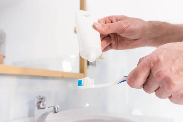 歯ブラシに歯磨き粉をかける人 歯の衛生管理 きれいな口腔ブラシの基本概念 — ストック写真