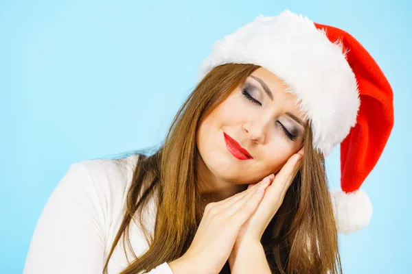 彼女の手で睡眠ジェスチャーをジェスチャーサンタの帽子を身に着けている疲れた女性 大人の女性は 昼寝をする準備ができて眠いです クリスマスタイム — ストック写真