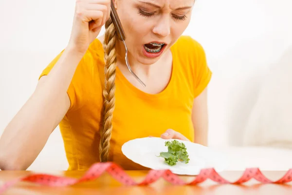 プレート上に小さな緑の野菜を持っている食欲不振神経症やビブリミアを扱う悲しい若いブロンドの女性 食事の問題 摂食障害 — ストック写真