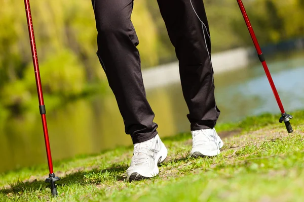 Nordic walking. Ženské nohy pěší turistika v parku. — Stock fotografie