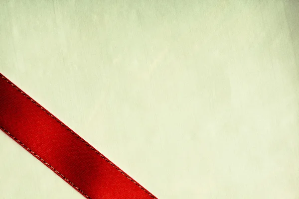 Shiny red ribbon stripe on green cloth background. — Stock Photo, Image