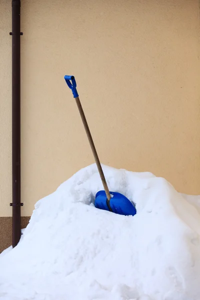 Pá de neve azul de pé na neve profunda — Fotografia de Stock