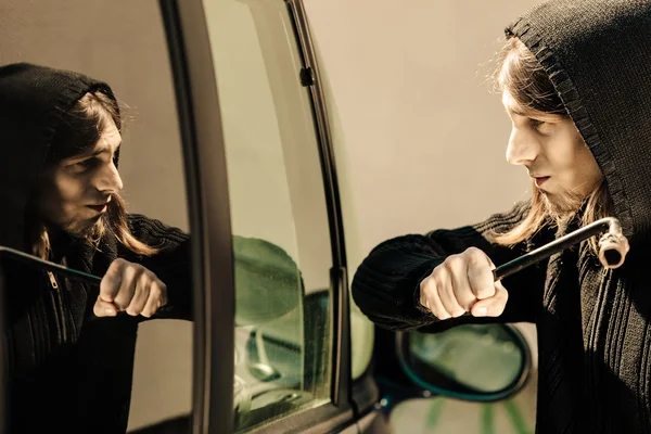 Transport et crime- voleur brisant fenêtre de voiture — Photo