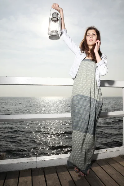 Chica en muelle con lámpara de queroseno — Stockfoto