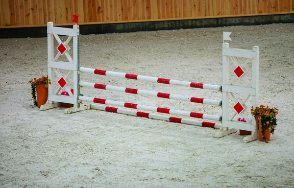 Obstáculo branco vermelho para pular cavalos. Competição de equitação . — Fotografia de Stock