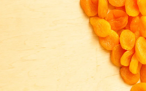 Border frame of dried apricots set on wooden background — Stock Photo, Image