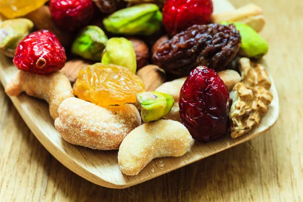 Varieties of dried fruits and nuts on wooden spoon. — Stock Photo, Image