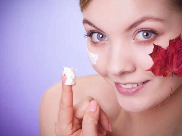 Hautpflege. Gesicht einer jungen Frau mit rotem Ahornblatt. — Stockfoto