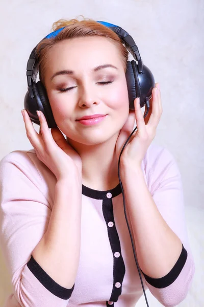 Femme moderne avec écouteurs écoutant de la musique — Photo