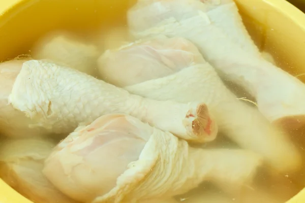Cerrar el muslo de carne de pollo crudo en agua — Foto de Stock