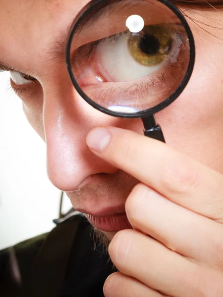 Man looking through a magnifying glass — Stock Photo, Image