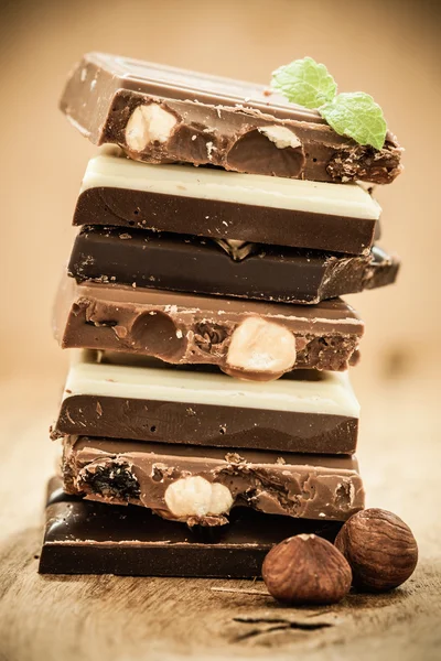 Stapel van verschillende soorten chocolade en hazelnoten — Stockfoto