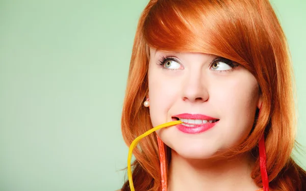 Redhair girl holding sweet food jelly candy on green. — Stock Photo, Image