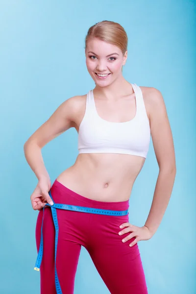 Fitness woman fit girl with measure tape measuring her loins — Stock Photo, Image