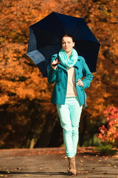 Chica caminando con paraguas azul en el parque otoñal —  Fotos de Stock