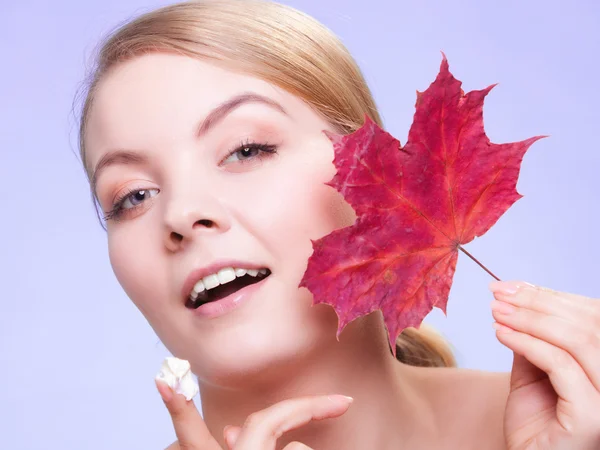 Cura della pelle. Volto di giovane donna ragazza con foglia d'acero rosso. — Foto Stock