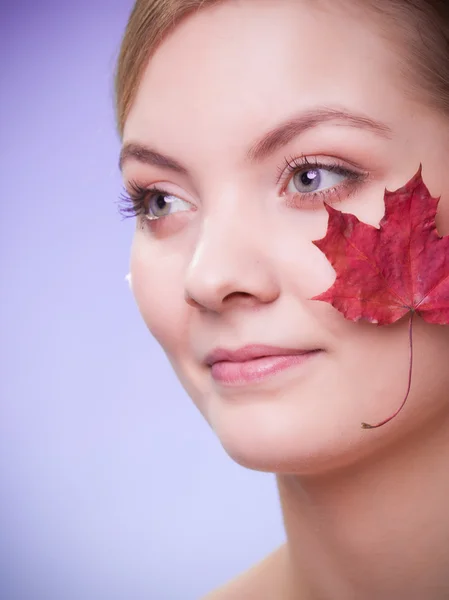 Skin care. Face of young woman girl with red maple leaf. — Stock Photo, Image