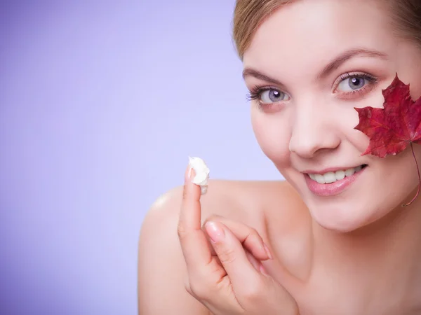 Cuidado de la piel. Cara de chica joven con hoja de arce rojo. —  Fotos de Stock