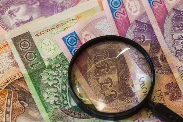 Polish zloty banknotes currency and magnifying glass — Stock Photo, Image