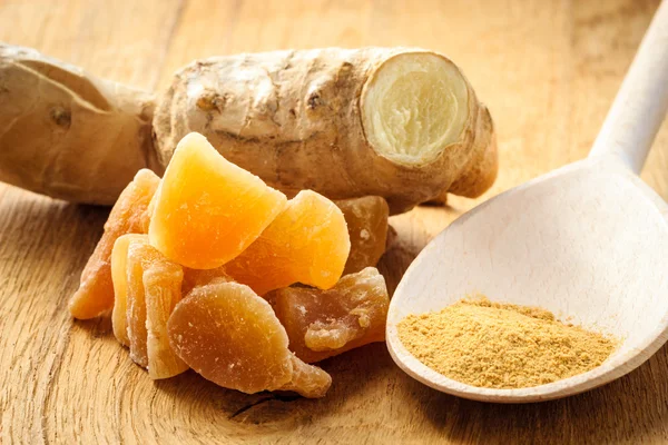 Candied fresh and ground ginger on rustic table — Stock Photo, Image