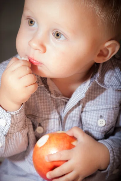 Kırmızı elma meyvesi yiyen tatlı erkek bebek. — Stok fotoğraf