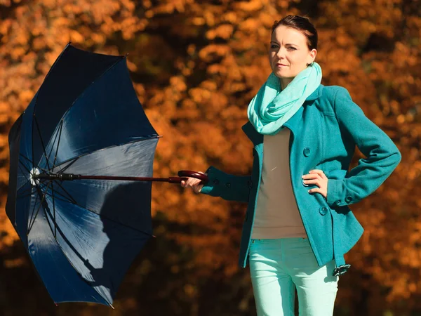 Sonbahar parkında mavi şemsiyeyle yürüyen kız. — Stok fotoğraf