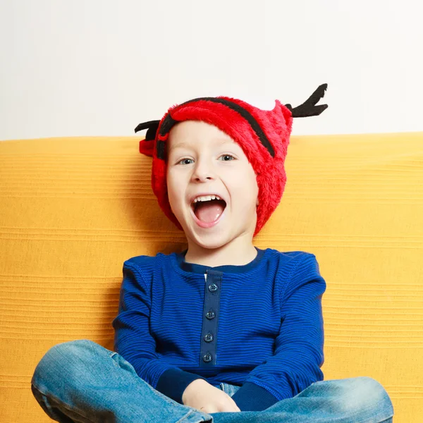 Liten pojke i röd vinter renar hatt hemma — Stockfoto