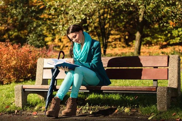 女孩在秋天的公园看书中放松。秋天. — 图库照片