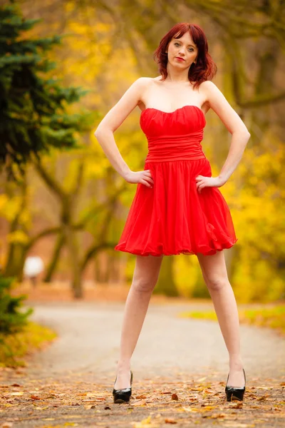 Žena v červených šatech v parku — Stock fotografie