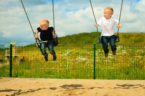 Brothers having fun on swing — Stock Photo, Image