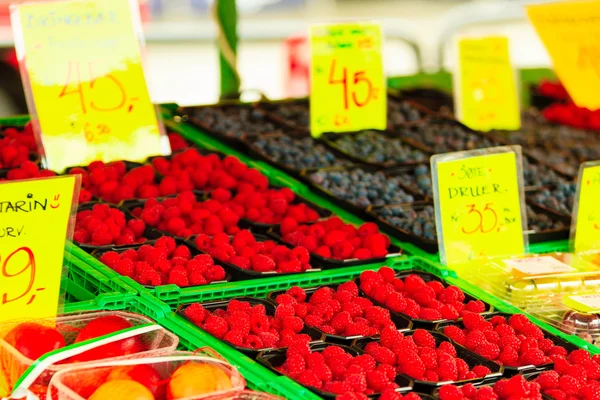 Framboesas em recipientes no mercado — Fotografia de Stock