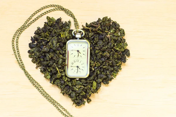 Green tea leaves and watch — Stock Photo, Image